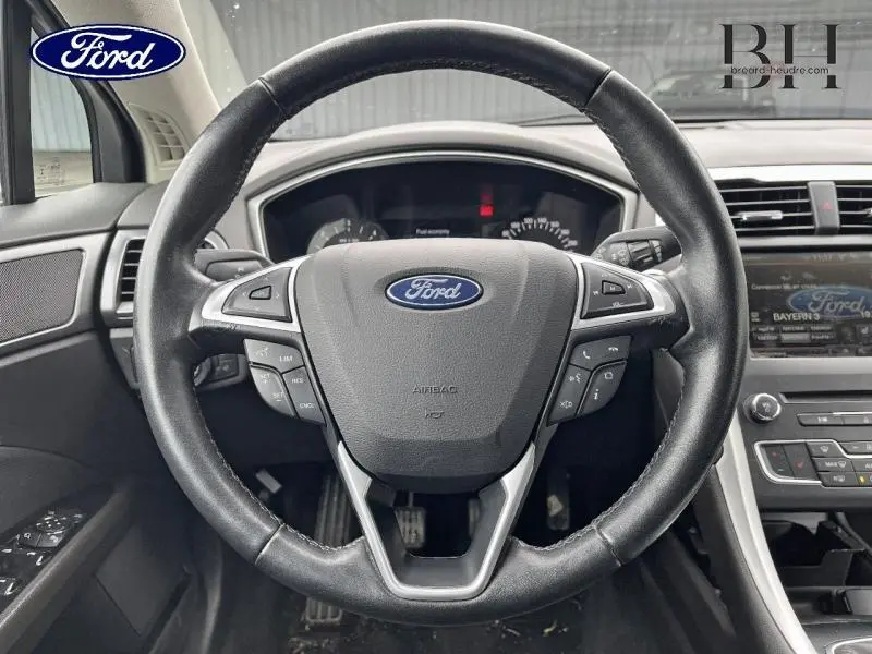 Vue frontale du volant cuir multifonction de la Ford Mondeo SW gris Magnetic, avec tableau de bord et écran tactile visibles.
