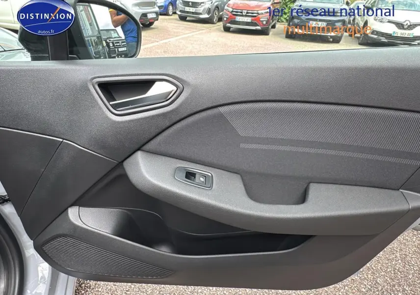 Intérieur montrant la porte côté gauche de la Renault Clio V gris rafale avec poignée argentée et commande de vitre électrique.