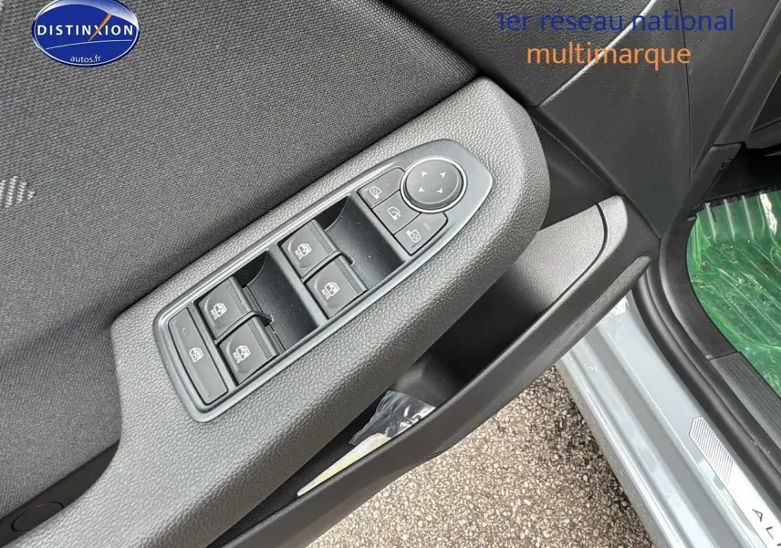 Gros plan sur la commande des vitres électriques côté gauche de la porte d'une Renault Clio V gris rafale.