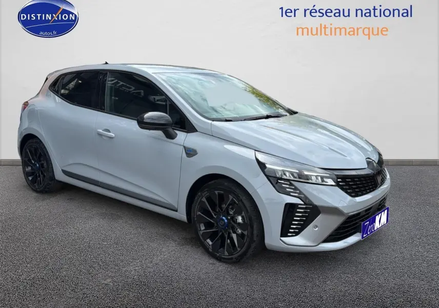 Renault Clio V gris rafale vue 3/4 avant droit avec jantes alu noires esprit alpine et calandre chromée.