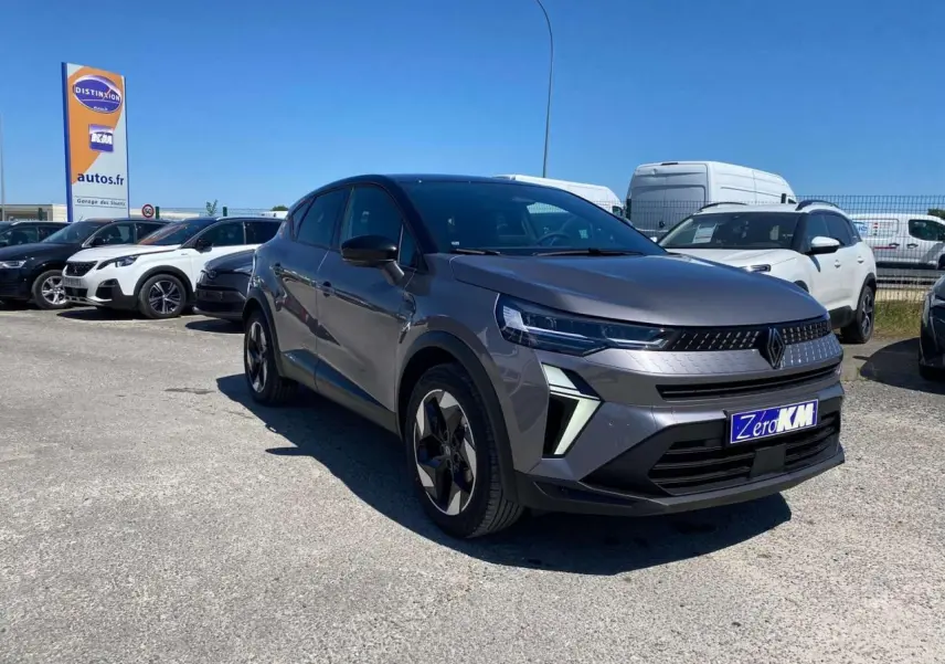 Renault Captur 2025 gris Cassiopée toit noir en 3/4 avant droit sur parking avec plaque Zero KM visible