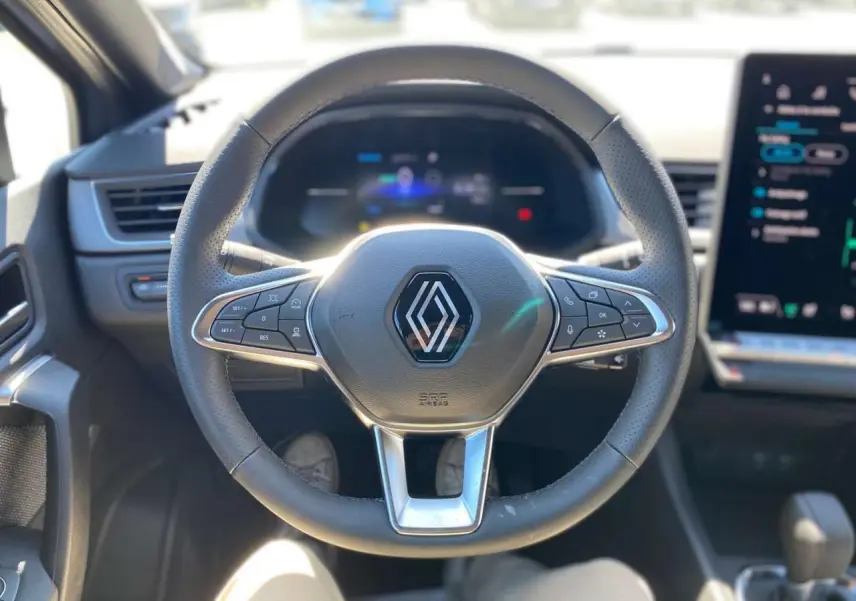 Vue rapprochée du volant cuir noir avec commandes intégrées du Renault Captur 1.6 E-Tech Hybride 2025.