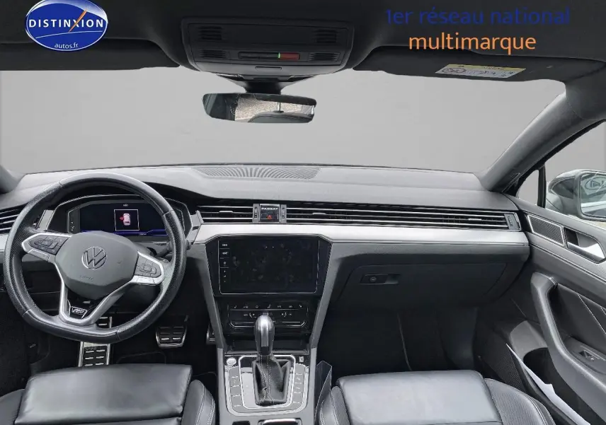 Intérieur noir de la Volkswagen Passat SW 2.0 TDI R-Line 2021, vue frontale du tableau de bord et volant sport cuir.