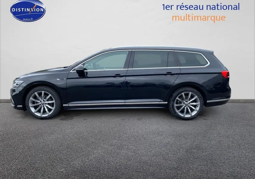 Profil côté gauche d'une Volkswagen Passat SW noire 2021 finition R-Line avec jantes alu et barres de toit chrome.