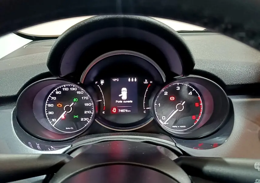 Vue rapprochée du tableau de bord de la Fiat 500X gris foncé, affichant les compteurs et l'écran central numérique.