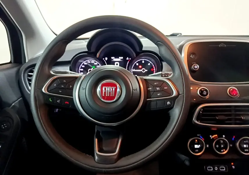 Vue intérieure centrée sur le volant et le tableau de bord du Fiat 500X 2019, avec écran tactile et commandes au volant.