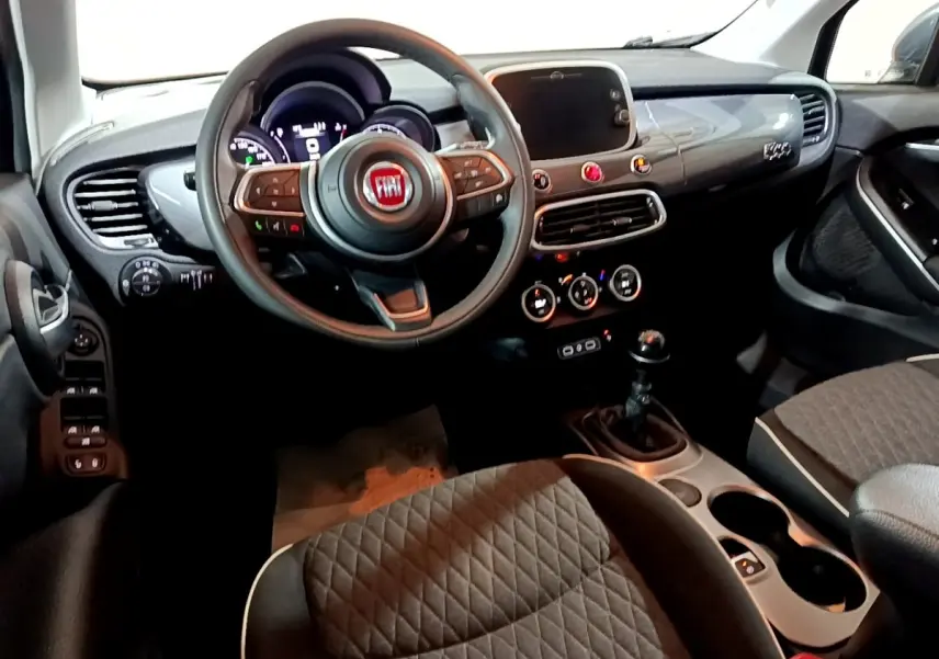 Vue intérieure avant droite du tableau de bord et volant noir de la Fiat 500X City Cross 2019 avec boîte manuelle.