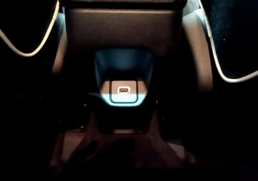 Gros plan sur la prise USB centrale éclairée dans l'habitacle sombre d'une Fiat 500X gris foncé.