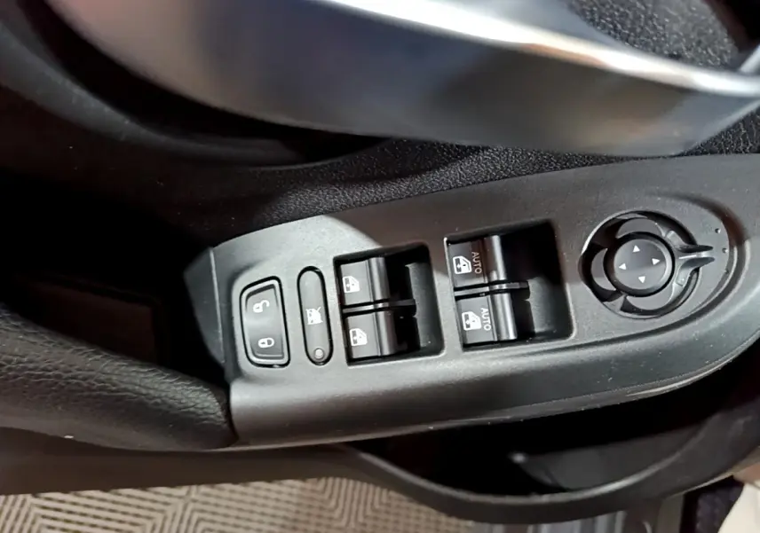 Gros plan sur les commandes des vitres et rétroviseurs côté conducteur d'une FIAT 500X gris foncé, version City Cross 2019.