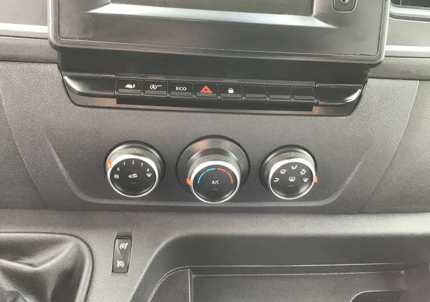 Vue rapprochée du tableau de bord noir du Renault Master avec commandes de climatisation et boutons fonctionnels.