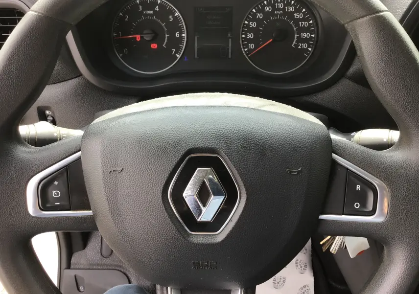 Vue rapprochée du volant noir avec logo Renault au centre et tableau de bord du Renault Master Châssis Cabine blanc.