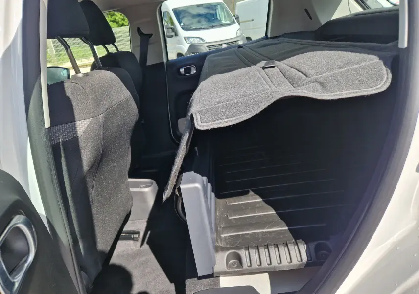 Vue intérieure côté droit de la Citroën C3 Société blanche, montrant les sièges arrière rabattus et le coffre aménagé.