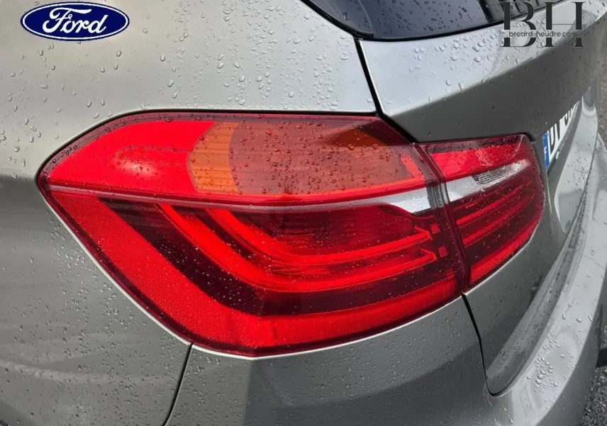Feu arrière droit de BMW Série 2 Active Tourer 216dA 2015 en Platinumsilber avec gouttes de pluie visibles.