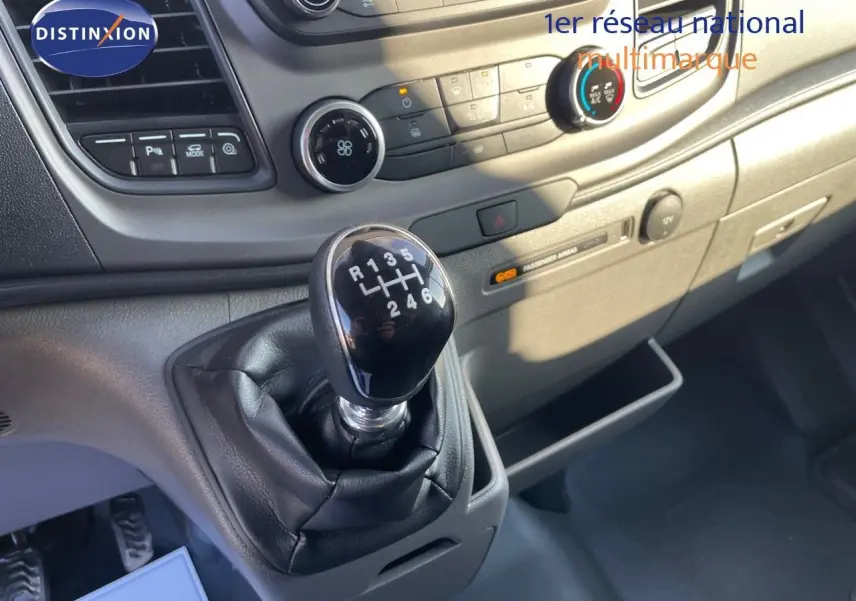 Gros plan sur le levier de vitesses manuel noir et la console centrale du Ford Transit Fourgon blanc 2023.