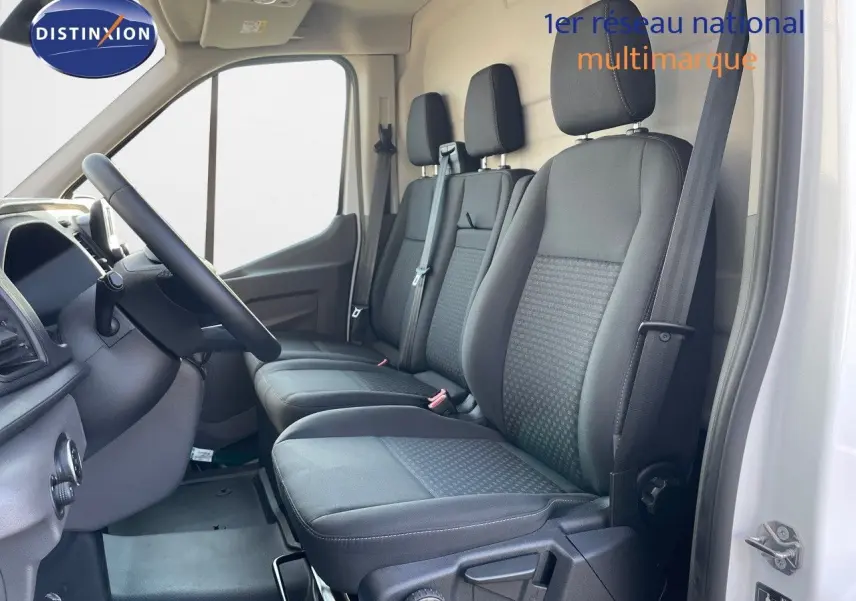 Intérieur côté conducteur du Ford Transit Fourgon blanc 2023, montrant les sièges noirs et le volant à gauche.
