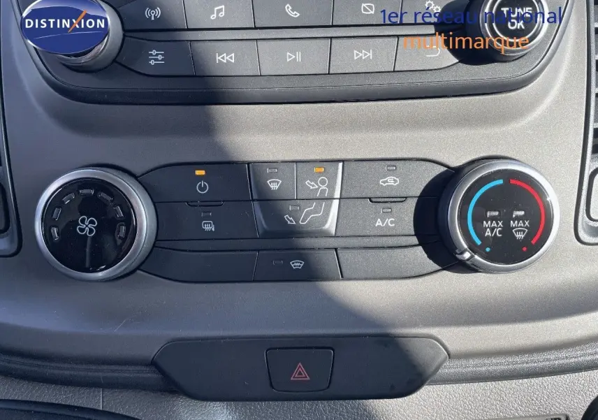 Gros plan sur la console centrale du Ford Transit Fourgon blanc 2023, montrant les commandes de climatisation et audio.