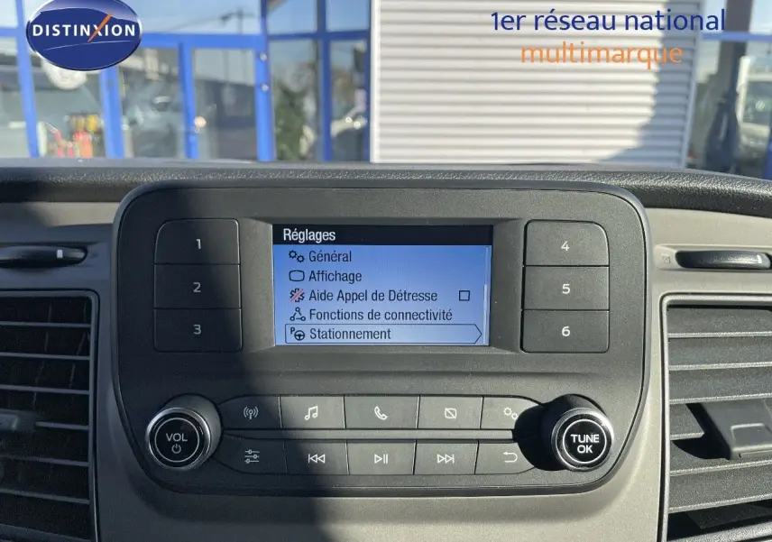 Tableau de bord du Ford Transit Fourgon 2023 avec écran central affichant les réglages, vue rapprochée intérieure.