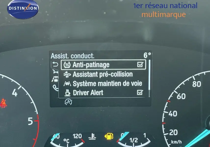 Vue rapprochée du tableau de bord du Ford Transit Fourgon blanc 2023 montrant les aides à la conduite activées.