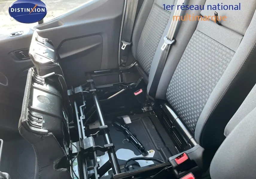 Vue intérieure côté droit montrant la banquette arrière grise et noire du Ford Transit Fourgon blanc 2023 avec siège relevé.