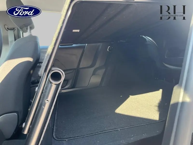 Vue intérieure du coffre arrière d'un Peugeot 208 AFFAIRE 1.5 BlueHDi 100 Premium, espace de chargement dégagé et tapis noir.