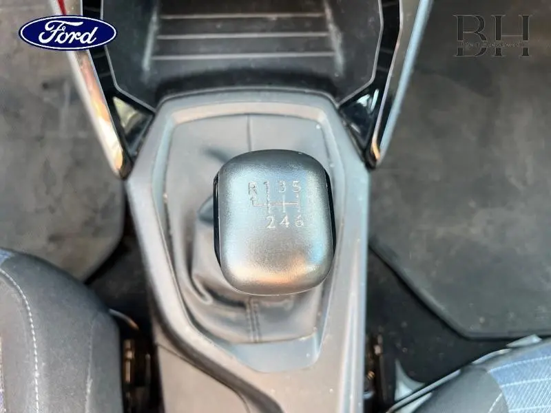 Le levier de vitesse manuel noir vu de dessus dans l'habitacle d'une Peugeot 208 Affaire blanc banquise.