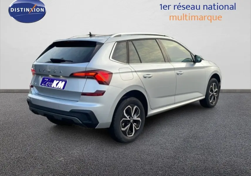 Vue 3/4 arrière droite d'un Skoda Kamiq gris argent métallisé avec jantes bi-ton et vitres teintées.