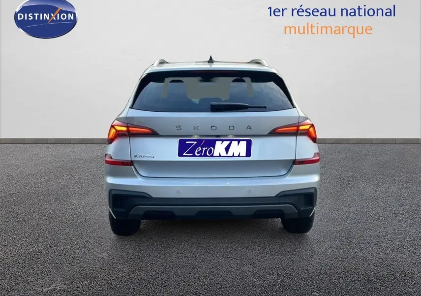 Vue arrière d'un Skoda Kamiq gris argent métal avec feux LED allumés sur fond neutre.