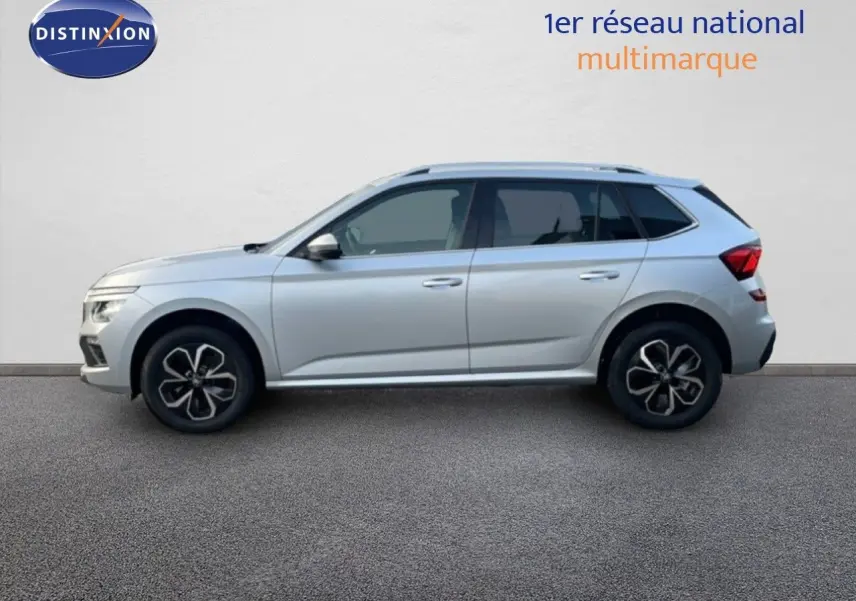 Vue de profil côté gauche d'un Skoda Kamiq gris argent métal avec jantes alliage noires et toit ouvrant.