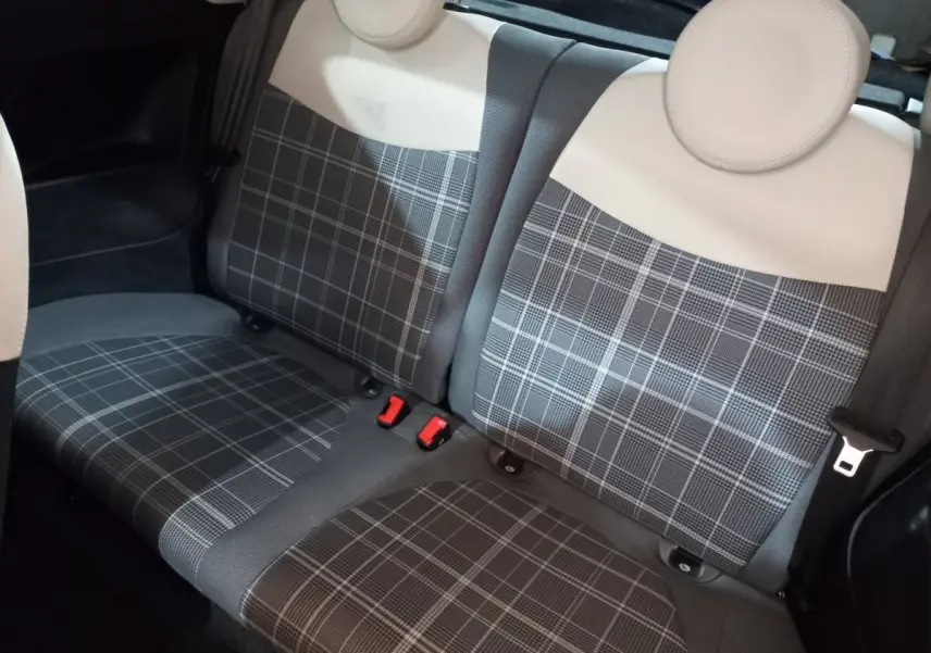Vue rapprochée de la banquette arrière à motif écossais gris et beige de la Fiat 500 Lounge noire de 2018.