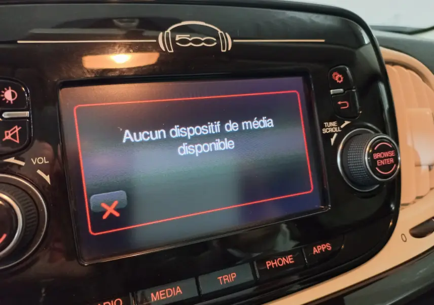 Vue rapprochée de l’écran tactile central noir du tableau de bord d’une Fiat 500 Lounge 2018 affichant un message d’absence de média.
