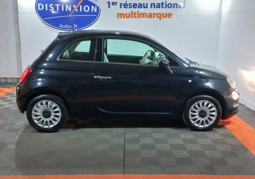 Profil côté droit d'une Fiat 500 noire 2018 avec jantes alliage et intérieur clair visible en showroom.