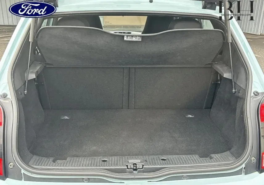 Coffre ouvert vu de l'arrière d'une Renault Twingo 2014 Bleu Dragée avec cache-bagages en place.