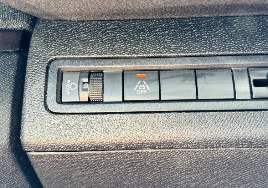Gros plan sur les commandes de réglage des phares et d'alerte de franchissement de ligne du Peugeot 3008 gris Artens.