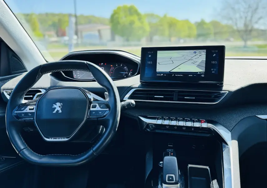 Intérieur Peugeot 3008 2021, vue tableau de bord avec écran GPS, volant compact et commandes modernes, ambiance lumineuse naturelle.