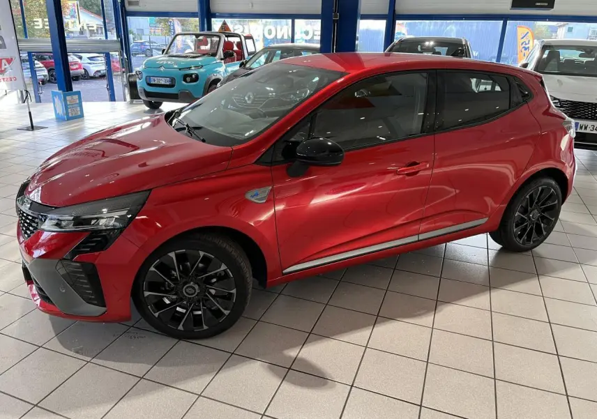 Renault Clio 2024 rouge vue de profil côté gauche, avec jantes noires et badge Esprit Alpine sur aile avant.