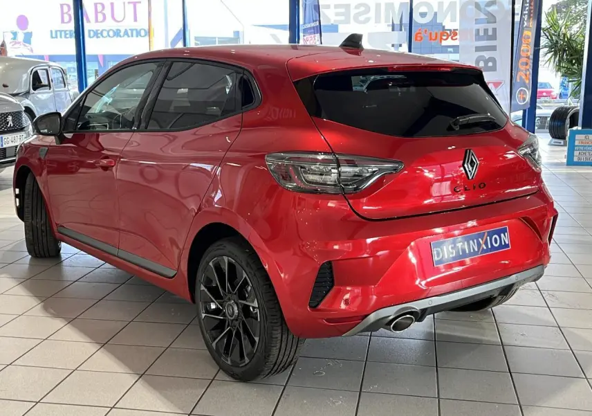 Vue 3/4 arrière droite d'une Renault Clio 1.0 Tce Esprit Alpine rouge, avec jantes noires et échappement chromé.