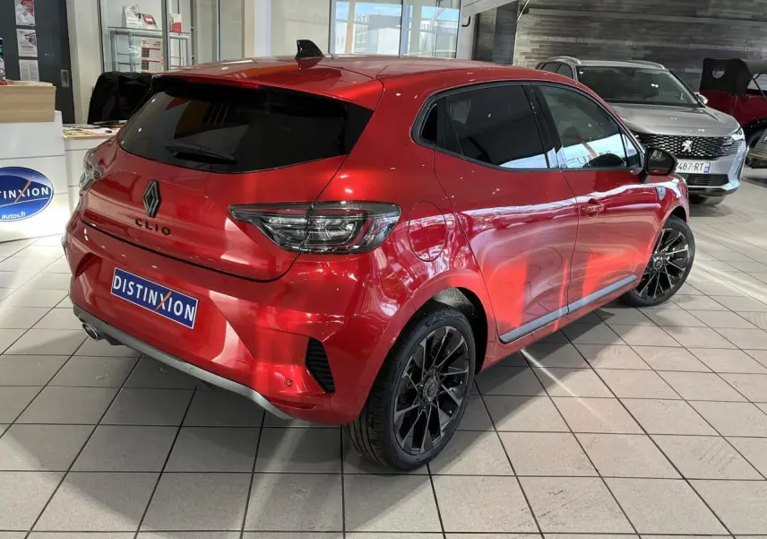 Renault Clio 2024 rouge vue 3/4 arrière droit en showroom avec jantes noires et feux LED en C.