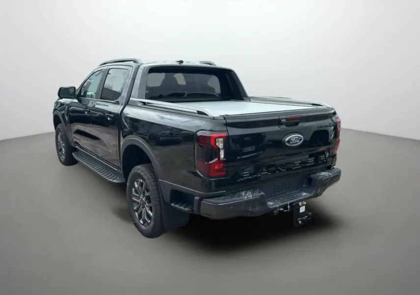 Ford Ranger 2025 noir agate vu 3/4 arrière droit avec benne couverte et attelage visible
