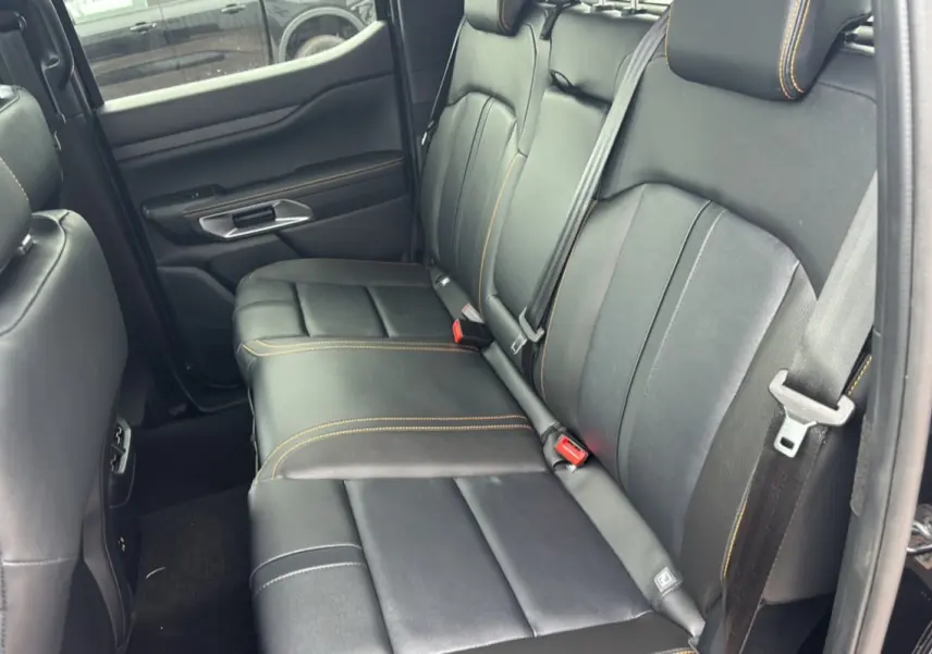 Vue côté droit de la banquette arrière en cuir noir avec surpiqûres orange du Ford Ranger Wildtrak Plus 2025.
