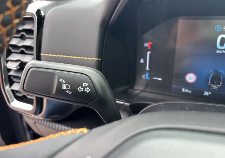 Gros plan sur le commodo de clignotants et tableau de bord numérique du Ford Ranger 2025 noir agate Wildtrak Plus.