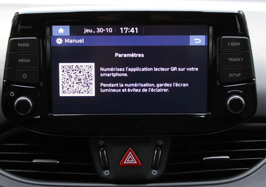 Écran tactile central affichant un QR code et les paramètres dans l'habitacle d'une Hyundai i30 SW argentée.