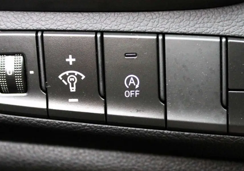 Panneau de commandes intérieures noires avec boutons de réglage des phares, du tableau de bord et contrôle de stabilité sur Hyundai i30 SW 2024.