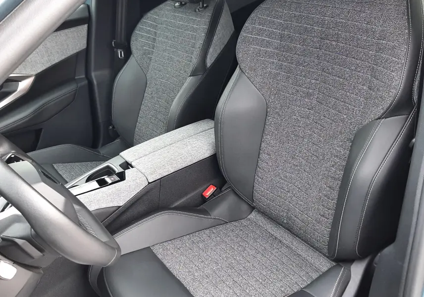 Vue intérieure rapprochée des sièges avant en tissu gris et cuir noir du Peugeot 3008 III HYBRID 145 ALLURE e-DSC6.