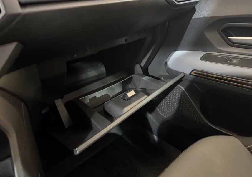 Vue intérieure côté passager du coffre à gants ouvert de la Dacia Sandero Extreme+ TCe 110 2024, avec détails en noir et gris.