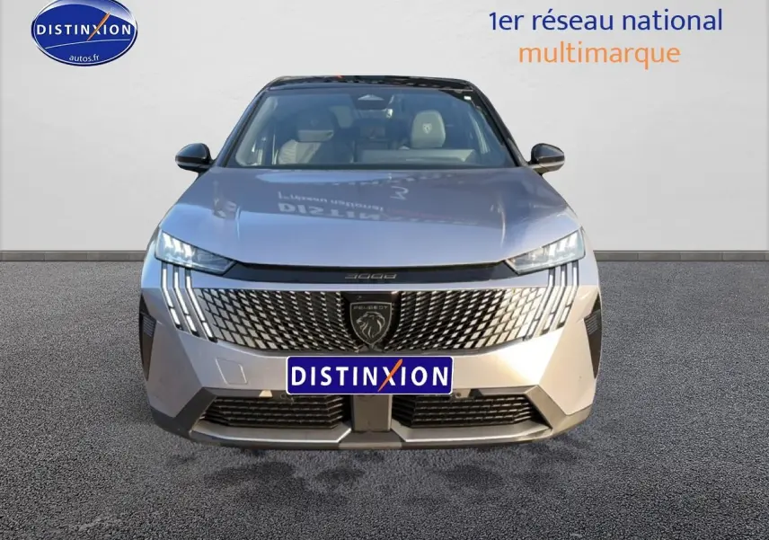 Vue frontale d’un Peugeot 3008 gris 2025 avec calandre distinctive et phares LED en forme de griffes.