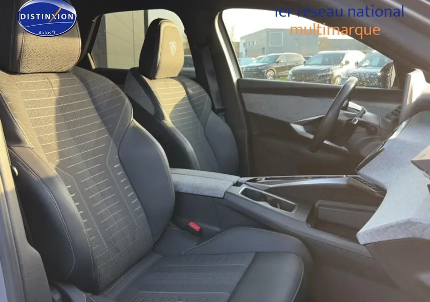Vue intérieure côté gauche des sièges avant gris et noir du Peugeot 3008 2025 avec accoudoir central et volant multifonction.