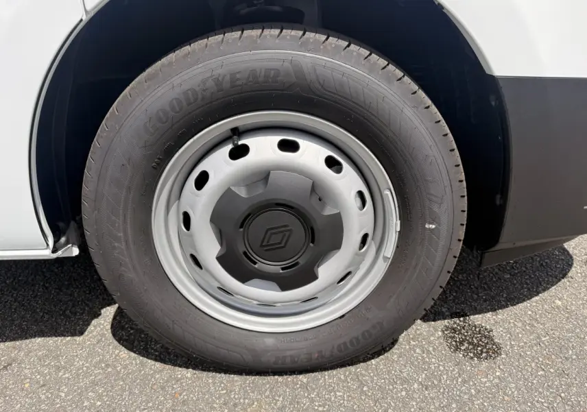 Gros plan sur la roue avant droite du Renault Trafic Fourgon blanc, avec jante acier et pneu Goodyear.