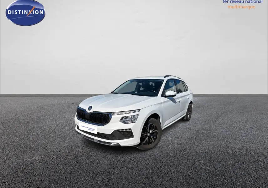 SUV Skoda Kamiq blanc en 3/4 avant droit, avec calandre noire et jantes alliage sombres sur sol gris.