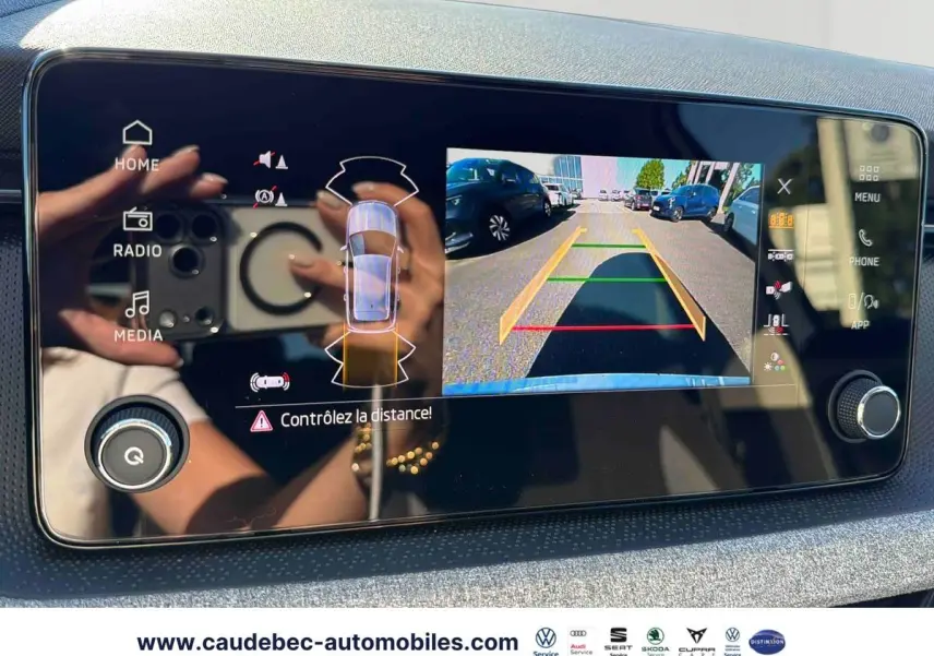 Écran tactile intérieur montrant la caméra de recul du Skoda Kamiq blanc avec guidage de trajectoire en parking.