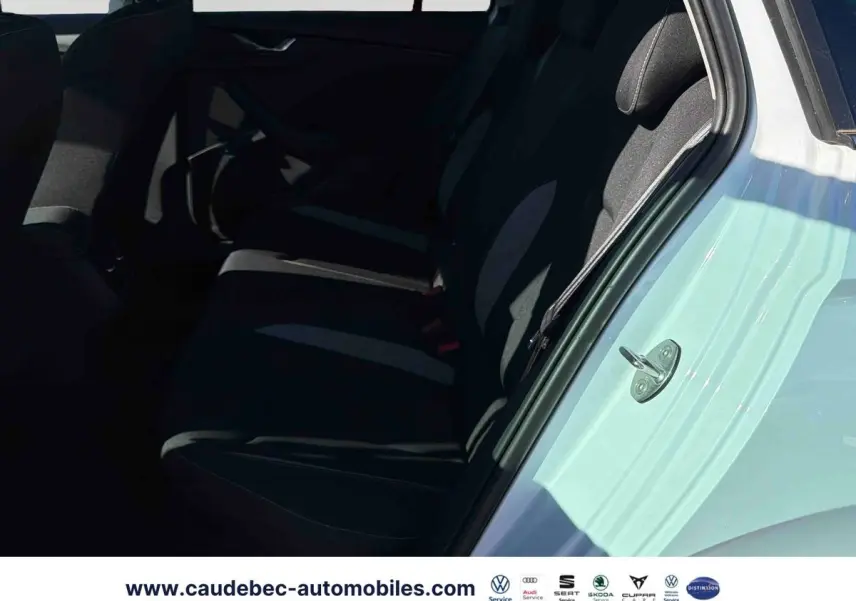 Vue intérieure côté arrière droit du Skoda Kamiq blanc, montrant les sièges arrière en tissu noir.